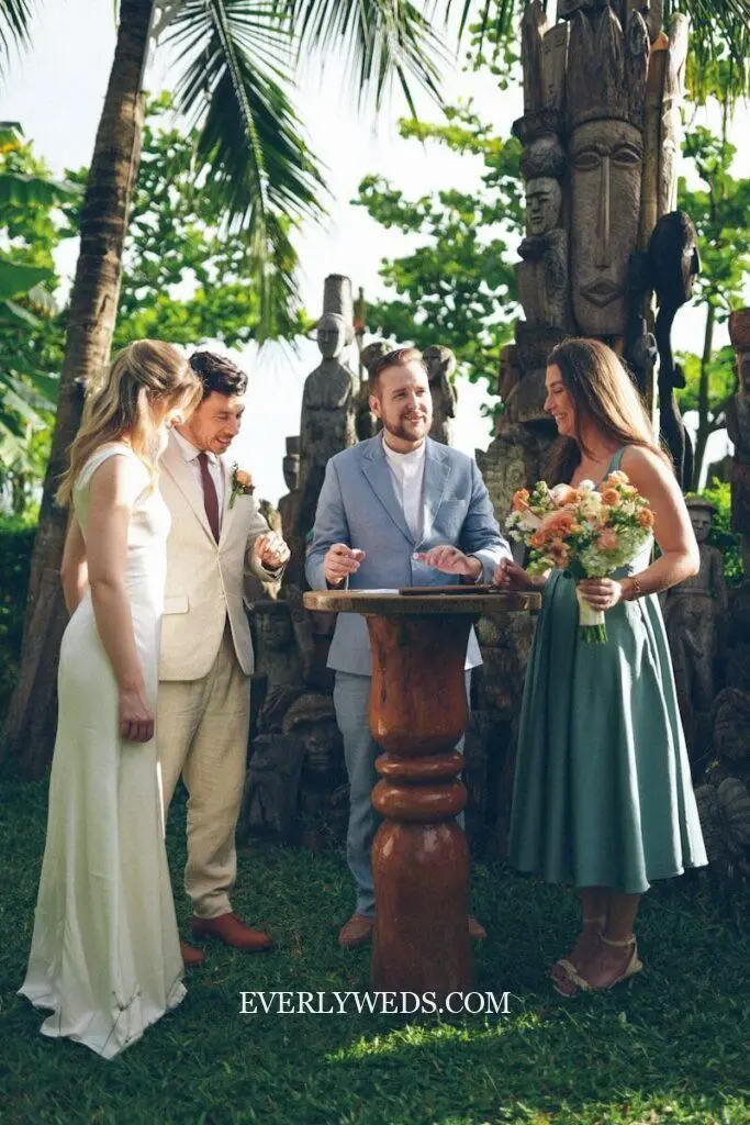 Couple signing wedding certificate outdoors with officiant