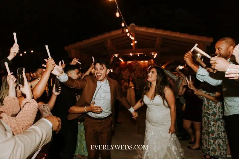 Couple celebrating with glow sticks at night wedding reception - creative save the date ideas inspiration
