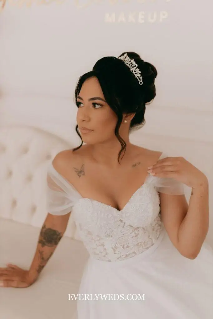 Beautiful bride in a white lace dress and tiara, exuding grace and elegance.