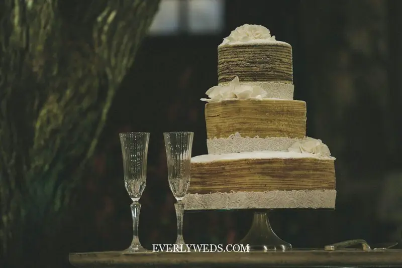 two clear wine glasses beside 3-layer towel cake