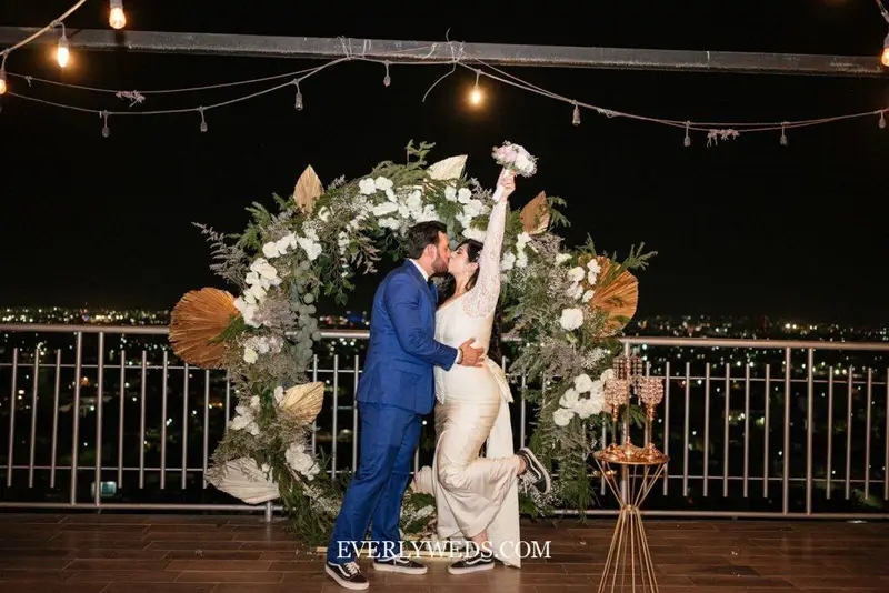 Modern wedding venue ideas outdoor rooftop ceremony with city skyline backdrop and geometric arch