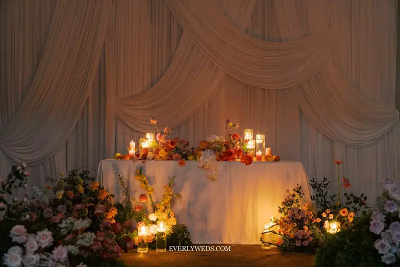 head table wedding set up with greenery runner candles and Mr and Mrs signs