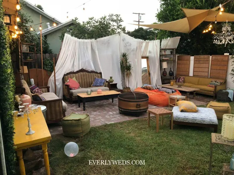 Modern wedding venue ideas outdoor backyard reception with market umbrellas string lights dining tables and floral ceremony arch