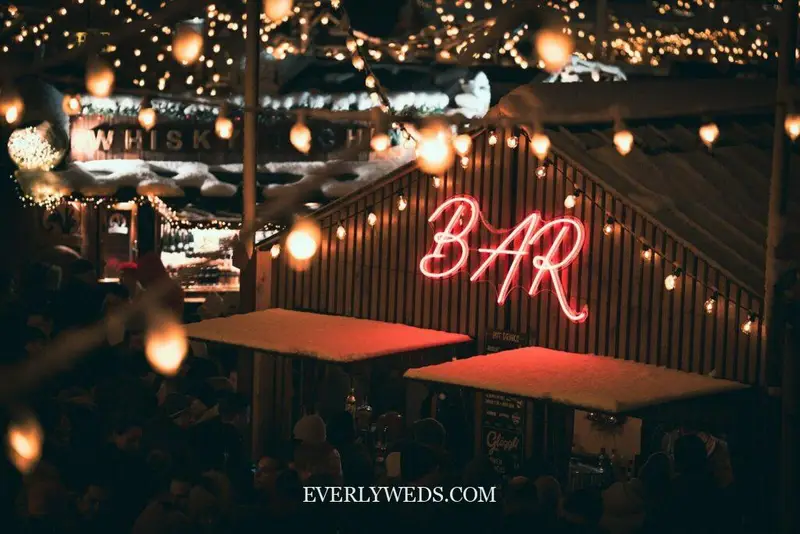champagne bubbly bar at wedding reception with gold acrylic sign and vintage glassware, romantic chic wedding venue decorations indoor elegant