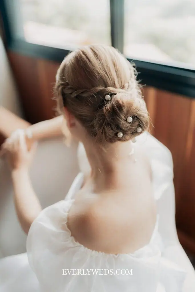 Bride's elegant bun is adorned with pearl pins.