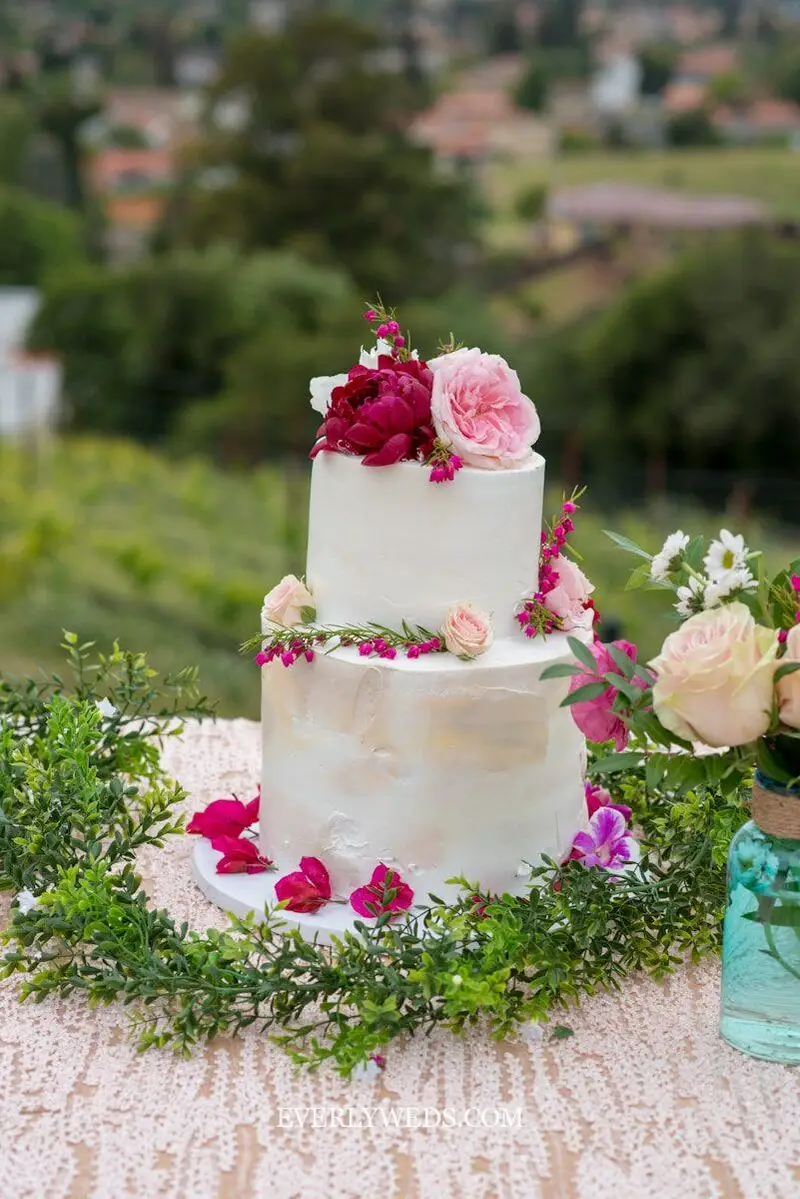 garden theme wedding cake 2 tier naked cake with fresh flowers and greenery on wooden cake stand rustic reception