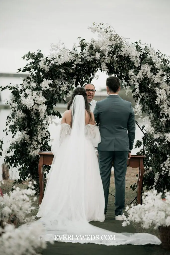 lush floral wedding ceremony backdrop with white and greenery flowers, wedding venue decorations flowers outdoor elegant