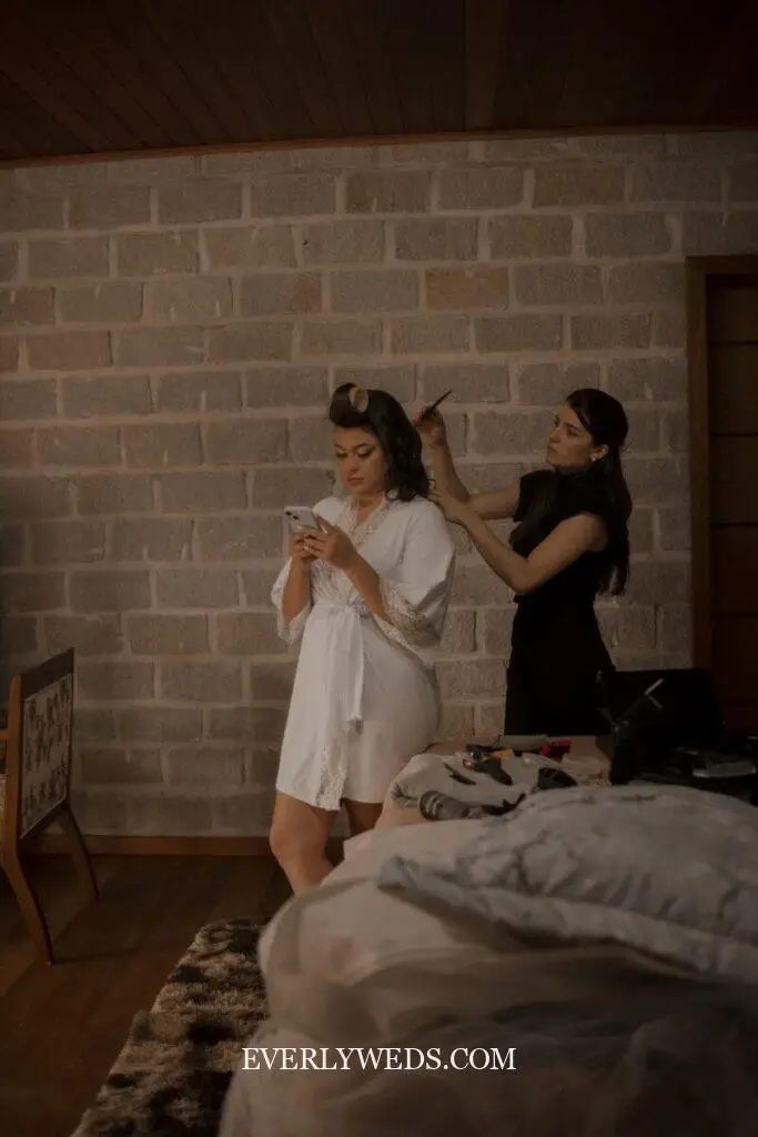 Bride getting ready while checking phone for save the date ideas inspiration