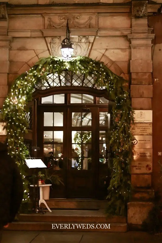 A man standing in front of a building with a christmas wreath on it