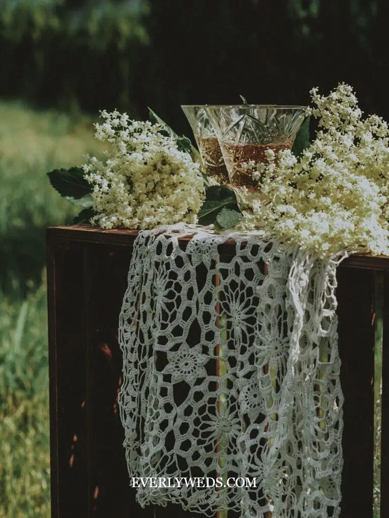 a table topped with a white table cloth and a vase filled with flowers