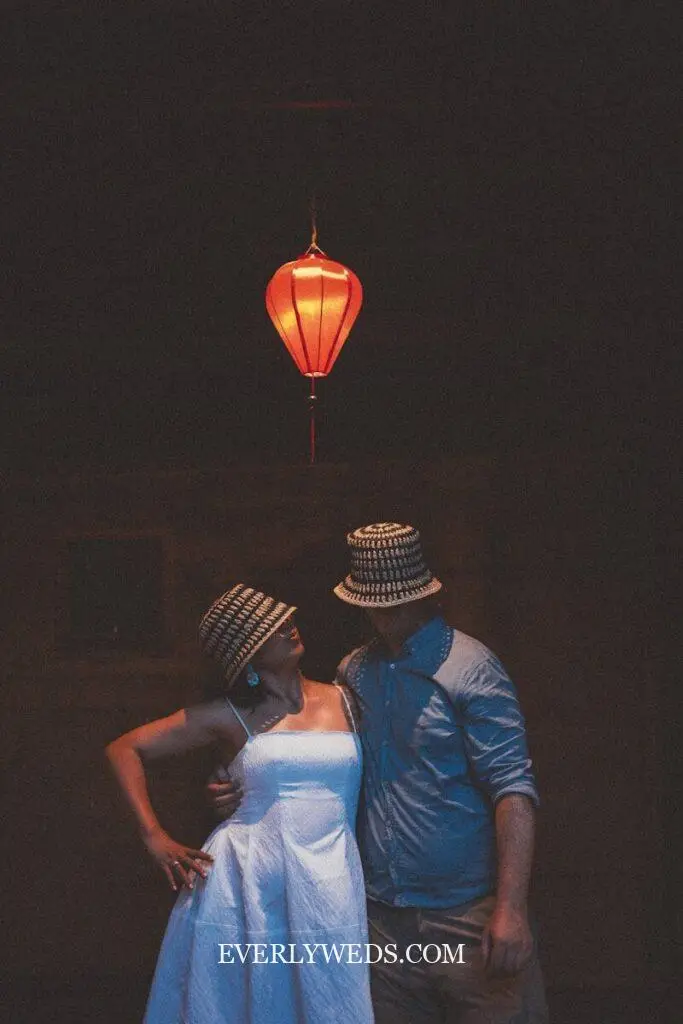 Couple looking at each other under a red lantern.
