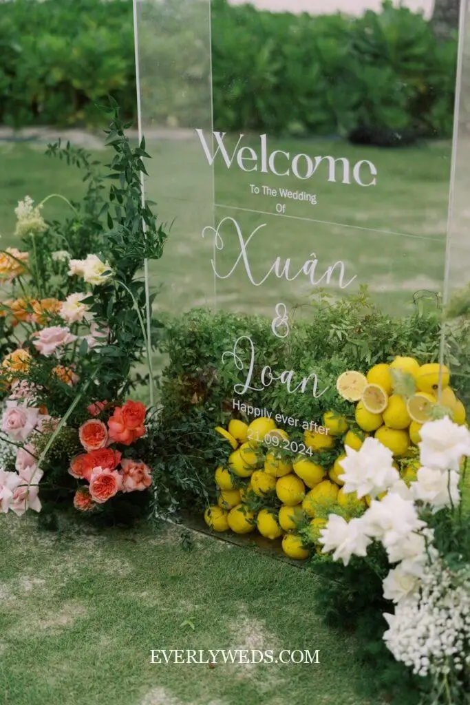 Wedding welcome sign decorated with flowers and lemons.