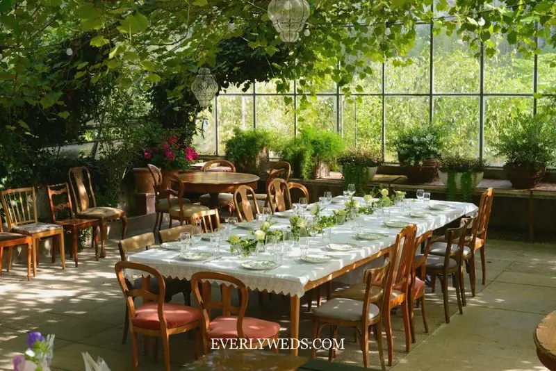 garden theme wedding indoor venue greenhouse reception with string lights and botanical decor