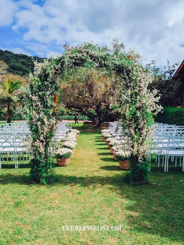 romantic floral archway wedding entrance decor with white roses and greenery at venue door