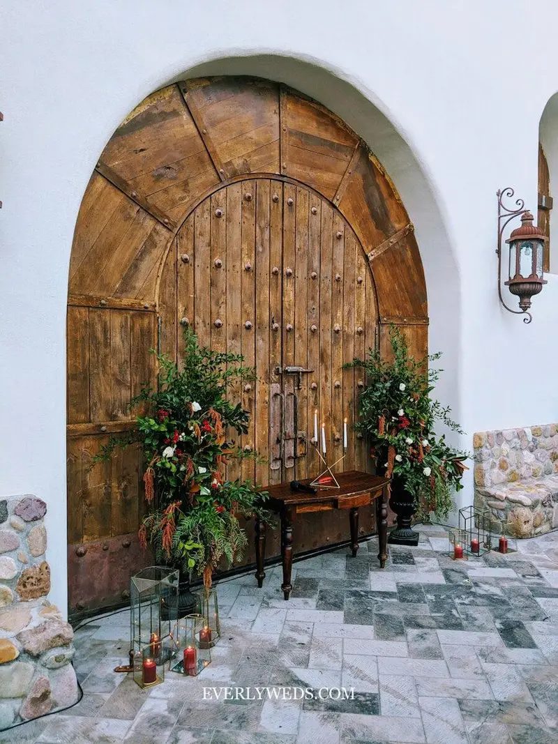 rustic wedding entrance ceremony backdrop with vintage barn doors and fresh greenery garland floral archway decor
