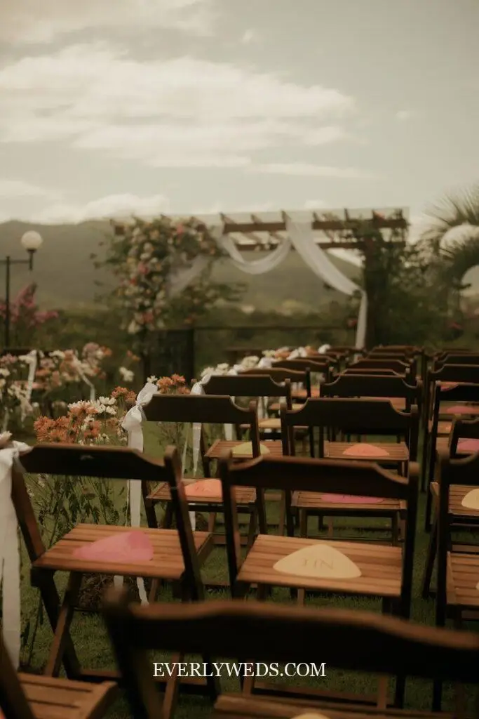 wedding ceremony aisle entrance with ribbon streamers and fabric tied to chairs romantic outdoor aisle decor ideas