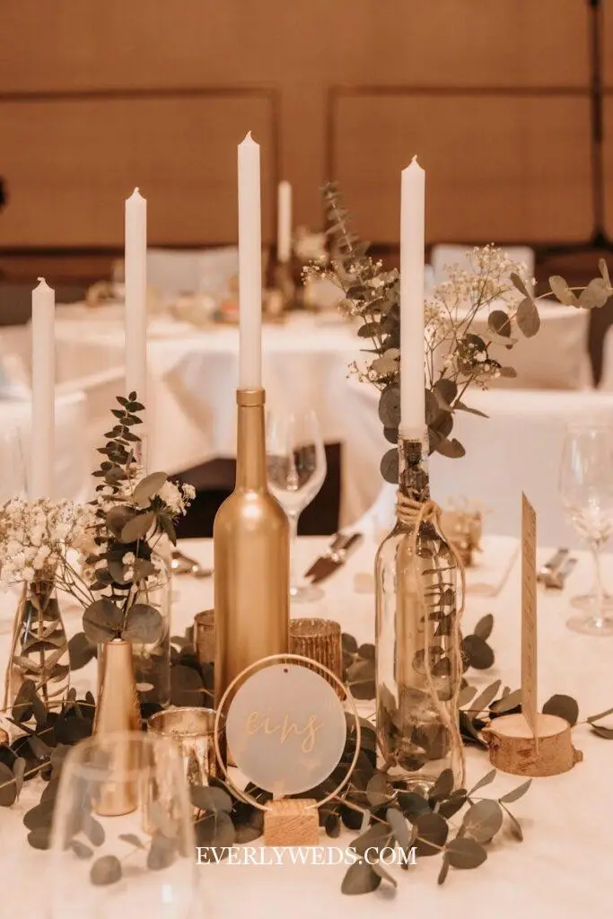 wedding venue decorations table with champagne centerpieces candles and greenery, elegant indoor wedding reception table decor
