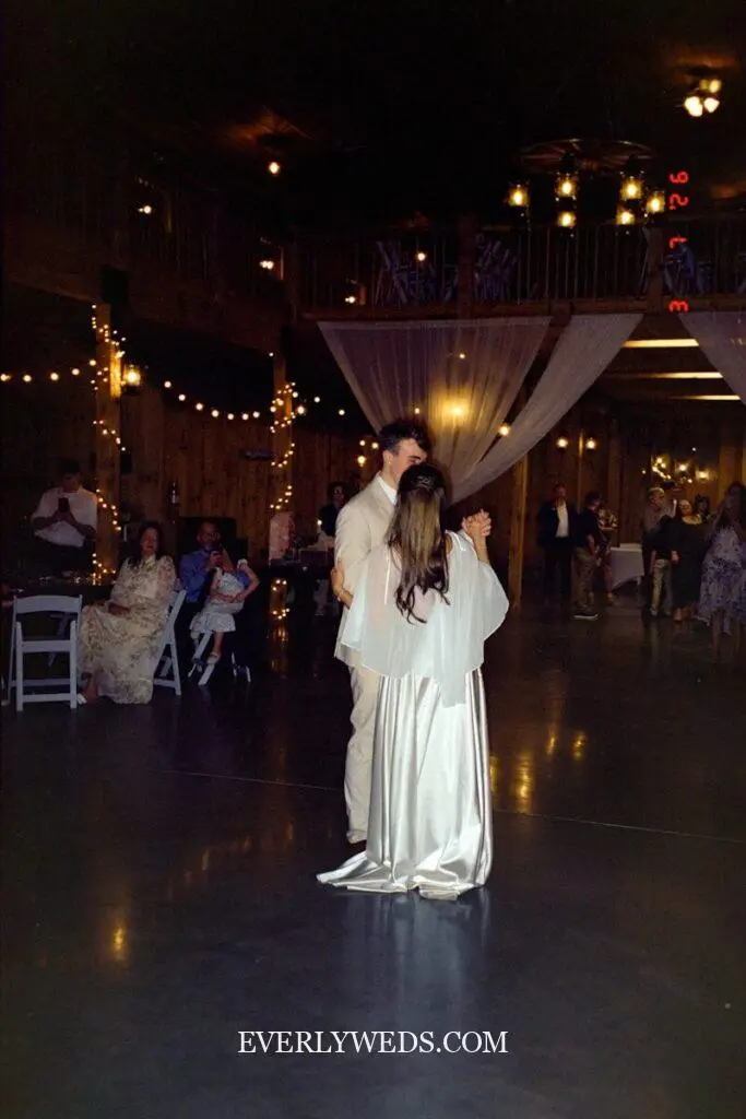 Modern barn wedding venue ideas with clean lines white interior and twinkle lights overhead