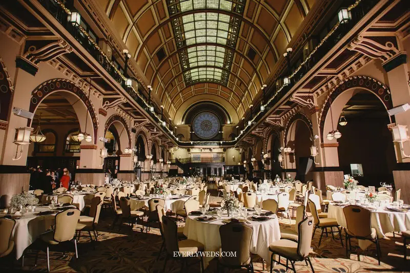 Modern wedding venue ideas indoor simple historic library venue with arched ceilings tall bookshelves and warm candlelight