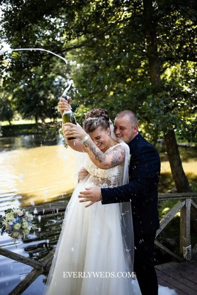 Couple celebrating with champagne spray - creative save the date ideas for weddings