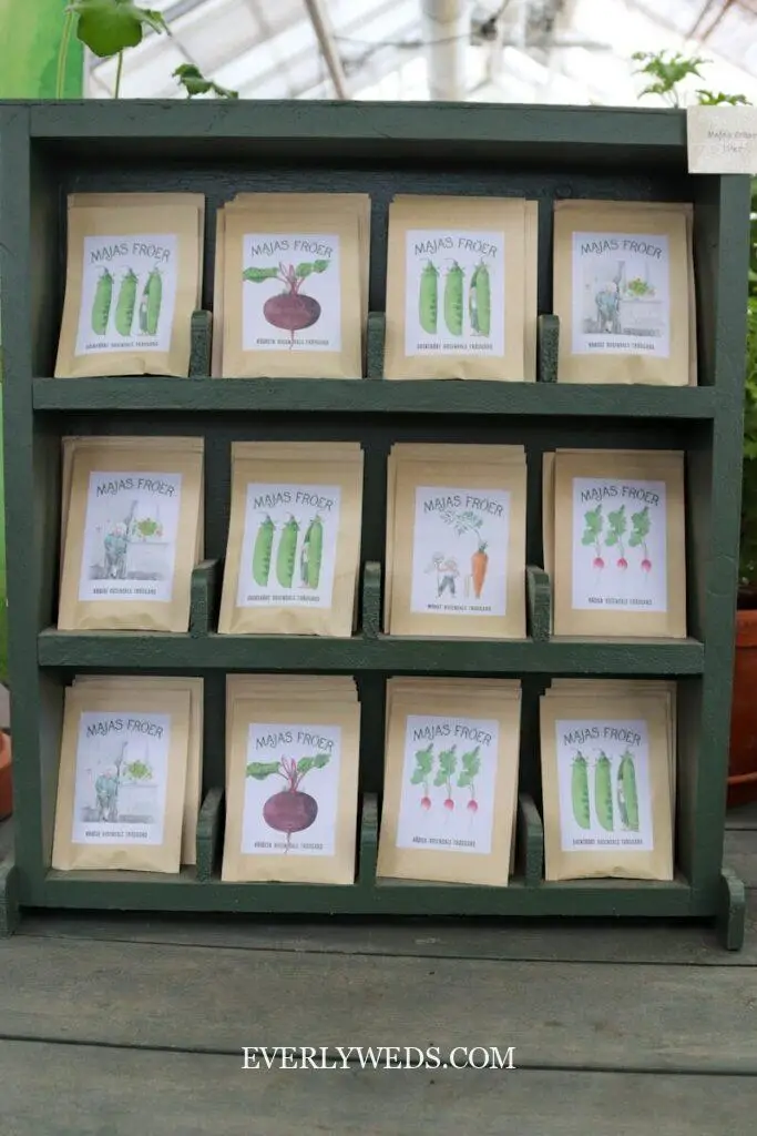 Seed packets are displayed on a wooden shelf.