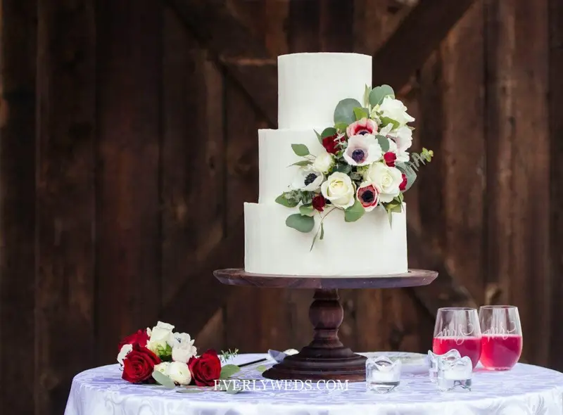 minimalist wedding cake design with smooth white buttercream and simple greenery accent modern style