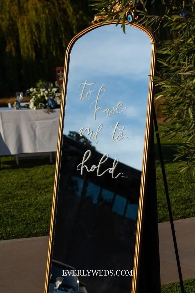 elegant wedding entrance sign on large gold mirror with calligraphy and floral accents entryway decor