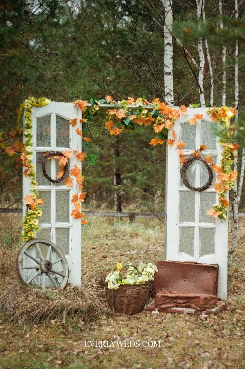 wedding set up photography photo booth backdrop with rustic door and floral greenery wall