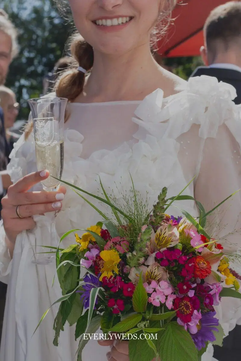 wedding set up outdoor drink station with vintage glassware signage and floral accents