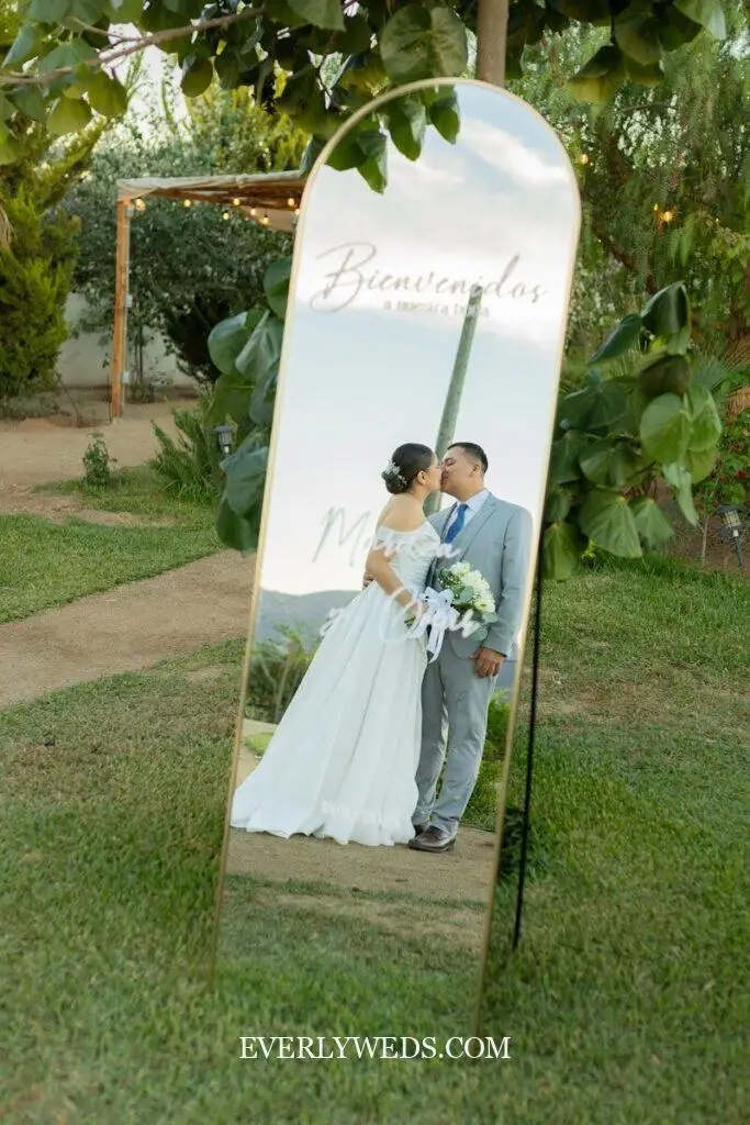 Elegant outdoor mirror wedding decoration with bride and groom reflection - budget backyard wedding decor idea
