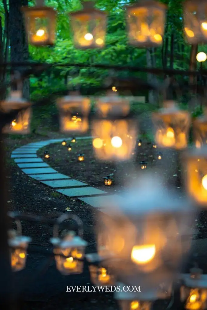 wedding entrance walkway lined with lanterns and candles leading to outdoor ceremony aisle decor