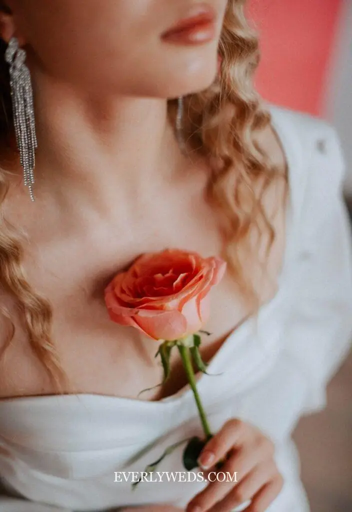 bridesmaid holding single stem white calla lily as unique bouquet alternative at outdoor wedding